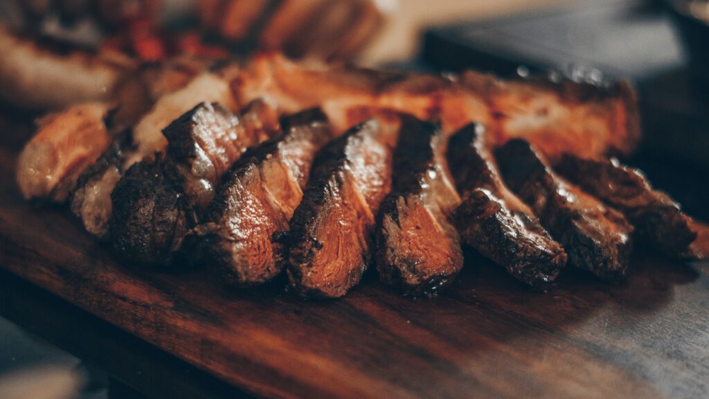 Sliced grilled steak on a wooden board