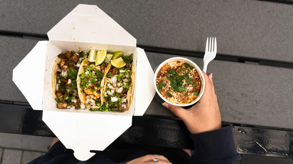 Person holding bowl of salad and soup