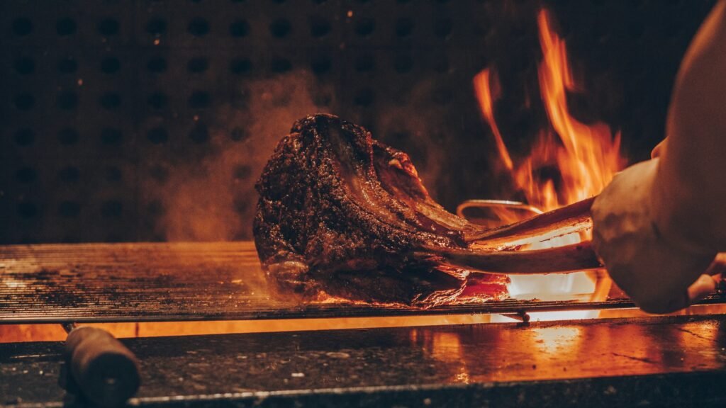Steak cooking over open flames