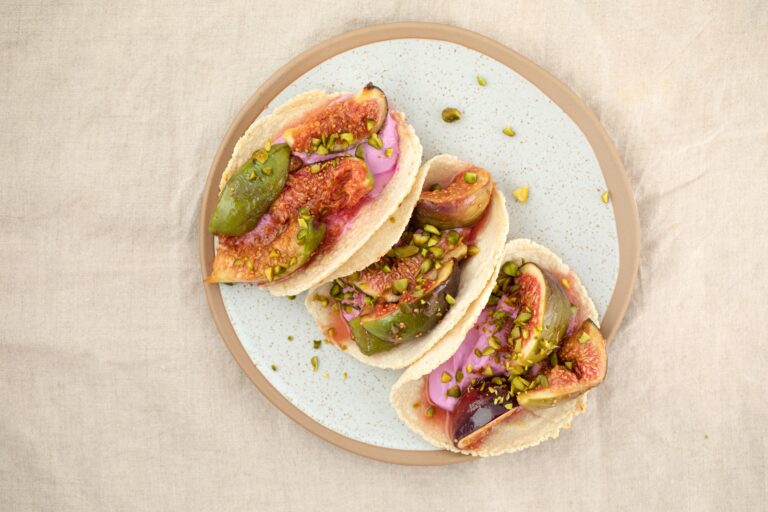 Three tacos on a white plate