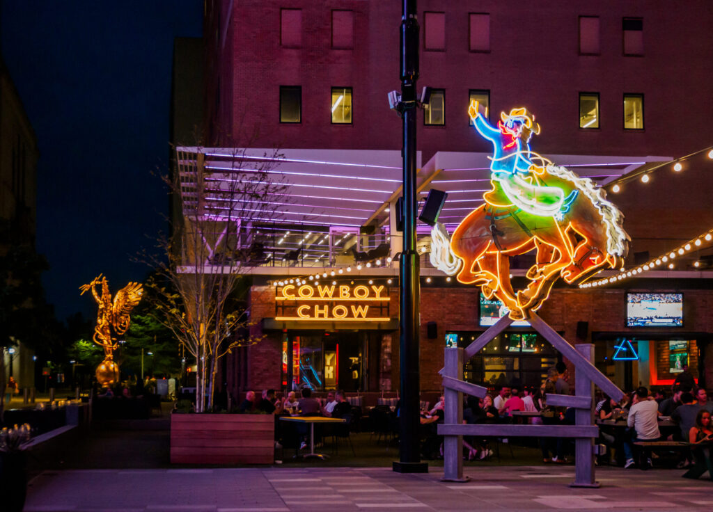 Neon dragon sign and storefront lights at night in an entertainment district