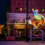 Neon dragon sign and storefront lights at night in an entertainment district