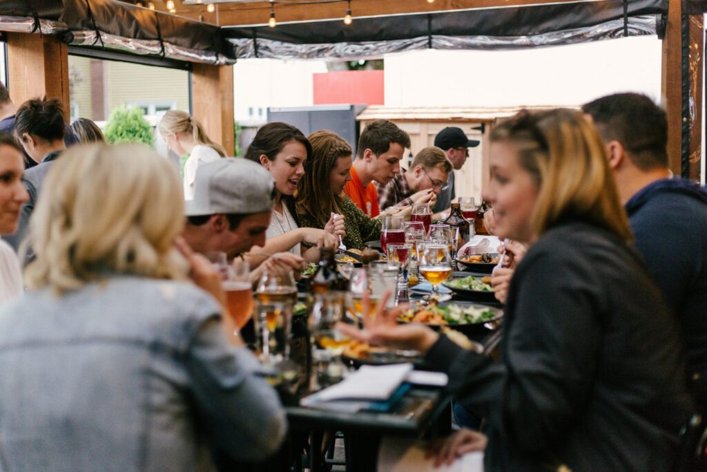 Group of people dining together and enjoying tacos at a busy restaurant table.